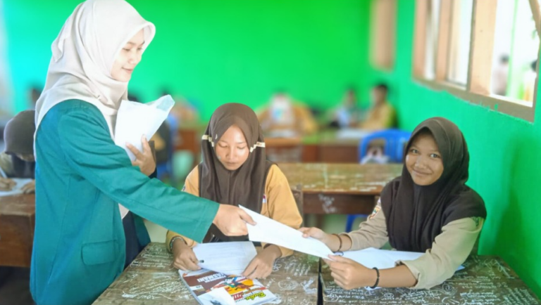Leni Suciati, mahasiswa PBSI Universitas Nurul Huda, membimbing siswa kelas 7A SMP Negeri 1 Tambakboyo saat uji coba soal Bahasa Indonesia Kurikulum Merdeka, Jumat (21/11/2025).